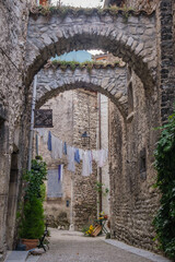 Fototapeta na wymiar Village scene with laundry hanging on a clothesline in a narrow street of the charming medieval village of Chatillon en Diois in the south of France (Drome)