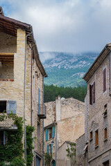 Street and Medieval House Facades in the Village of Chatillon en Diois with the Mountain Hidden Behind Clouds in the Background.