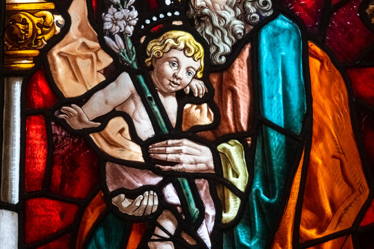 Beautiful stained glass window with a religious image of the baby Jesus, colorful and translucent in a church.