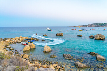Konnos bay beach in Cyprus next to the Mediterranean Sea in the late afternoon with pleasure boats in motion. Summer September 2023