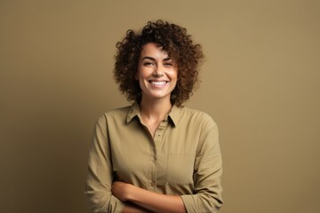 Fototapeta na wymiar Portrait of a smiling young african american woman with curly hair looking at camera on a brown background