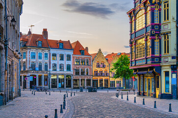 Vieux Lille old town quarter with empty narrow cobblestone street, paving stone square with old...