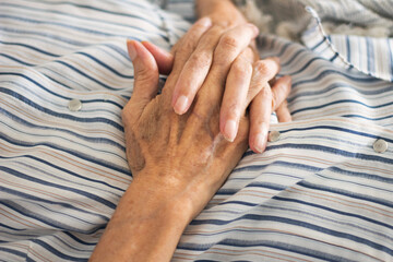 Old wrinkled woman hand. Old woman lying and hold her hands. Care for the health of old people