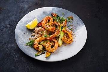 Traditional Thai fried king prawns with Asian vegetable and rice served as close-up on a design plate with text space