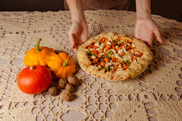 pumpkin galette, open pie on beige knitted tablecloth. autumn dinner still life in cozy kitchen