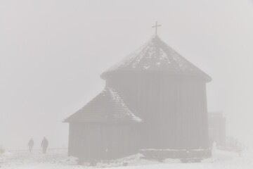 Church in the snow in the fog on the top of Mount Śnieżka in the Karkonosze massif in Lower...