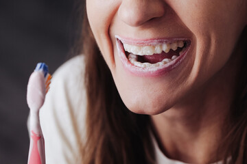 Brushing teeth background. Toothpaste foam. Young girl brushing her teeth. Smiling and laughing. Brushing teeth is fun. Lifestyle background. Mouth hygiene. Oral care. Happy woman smile closeup.