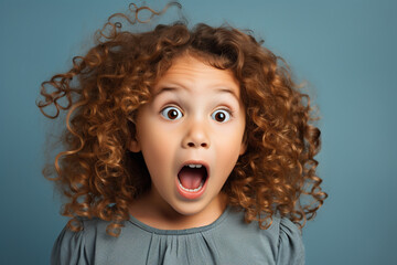 young girl with curly hair expressing total surprise - obrazy, fototapety, plakaty