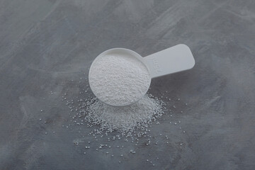 Sodium percarbonate or sodium carbonate peroxide in measuring spoon. White granulated powder. Chemical substance with formula Na2H3CO6 used in eco-friendly bleaches and other cleaning products - obrazy, fototapety, plakaty