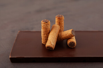 Delicious chocolate wafer rolls. Waffle tubes with milk chocolate filling, close-up. Selective focus, copy space