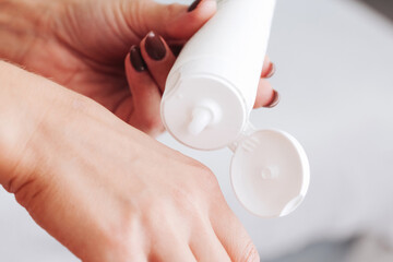 Skin care background. Hand cream use. Closeup of skin and container. Cosmetics background. Hands...