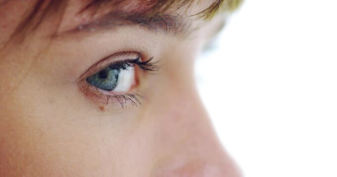 Profile closeup of a woman with blue eyes in studio with her pupils dilating with beautiful long eyelashes. Macro zoom of a girl with optical eyesight and a human eyeball vision with iris and sclera.
