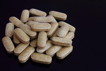 ayurvedic indian traditional herbal medicine or vitamin tablet for health,ayurvedic,phrmacy,naturopathy related concept in black background,top view
