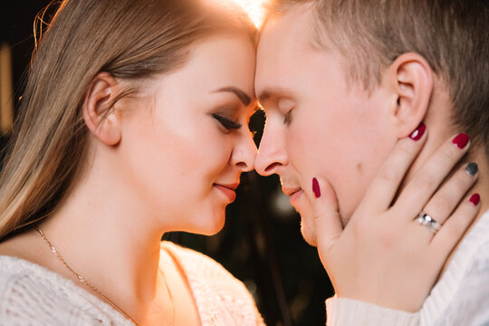 Close-up portrait of man and woman together, happy, looking at each other. Smiling, kissing and laughing.