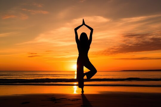 woman practicing yoga on the beach at sunset
