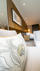 Cushion with floral design in pastel shades in a bedroom with a picture 