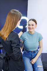Fototapeta premium Marking a woman's face before permanent eyebrow makeup. Eyebrow tattoo. Beauty procedure for a woman's face