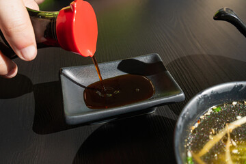 Pouring Soy Sauce in Japanese Ceramic Bowl in Sushi Restaurant