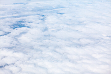 Fototapeta na wymiar White clouds and sky as seen through the window of an aircraft