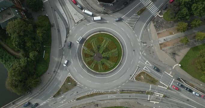 drone footage of a roundabout in "L&uuml;beck" with a green garden in the middle timelapse