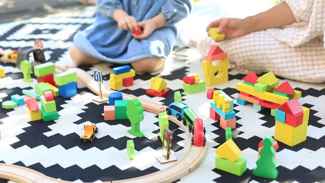 The child together with his mother plays an educational wooden set. 