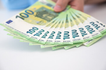 Closeup of hundred Euro banknotes on the table . Loan,salary,savings,cost of living,busines concept.Selective focus