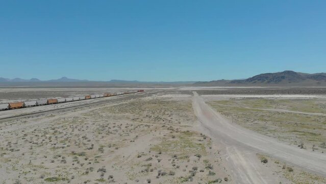 Drone flying accross the railroad of the trona pinnacles in the california desert at sunrise 4k