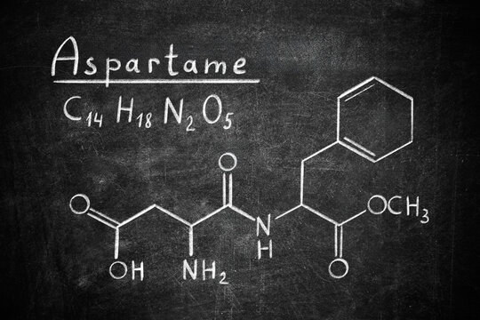 Formula of aspartame (chemical and structural) written on blackboard. Sugar substitute