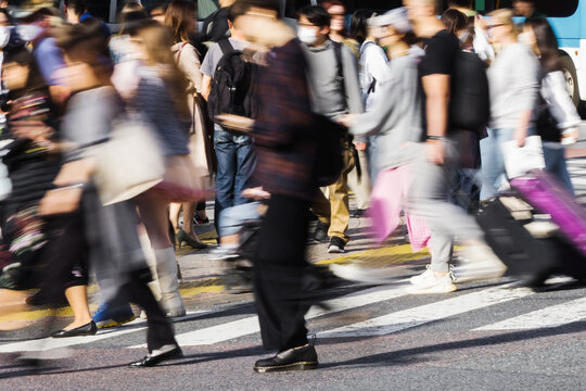 crowds of people crossing the Shibuya crossing in Tokyo, Japan