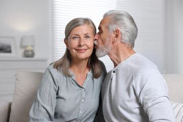 Fototapeta na wymiar Senior man kissing his beloved woman at home
