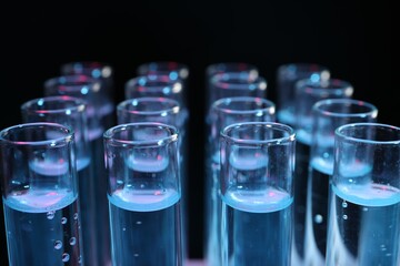 Test tubes with liquid on black background, closeup. Laboratory analysis