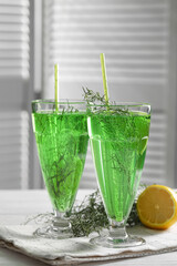 Glasses of homemade refreshing tarragon drink on table