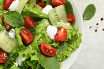 Delicious vegetable salad on light grey table, flat lay. Space for text