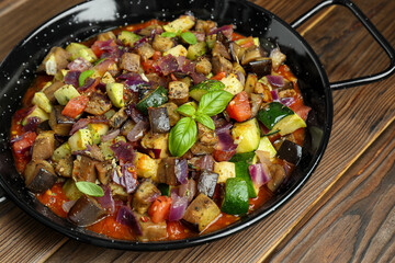 Delicious ratatouille in baking dish on wooden table, closeup