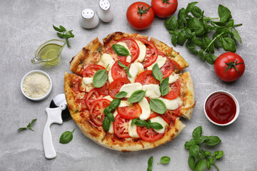 Delicious Caprese pizza with tomatoes, mozzarella and basil on light grey table, flat lay - Powered by Adobe