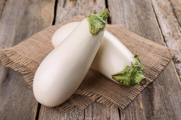 Two fresh white eggplants on wooden table