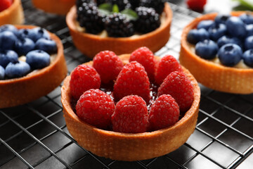 Tartlet with fresh raspberries on cooling rack, closeup. Delicious dessert