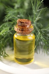 Obraz na płótnie Canvas Bottle of essential oil and fresh dill on light tray, closeup