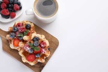Delicious Belgian waffles with fresh berries on white table, flat lay. Space for text
