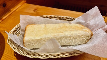 bread and butter Toasted bread with garlic butter in a basket on a wooden table