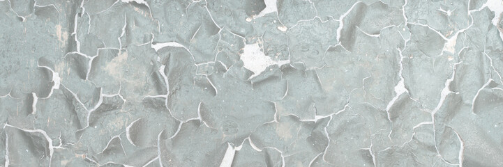 Peeling paint on the wall. Old concrete wall with cracked flaking paint. Weathered rough painted surface with patterns of cracks and peeling. Grunge texture for background and design. High resolution.