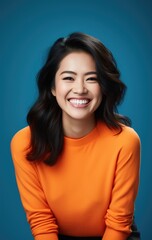Obraz premium A happy woman wearing an orange top with a radiant smile