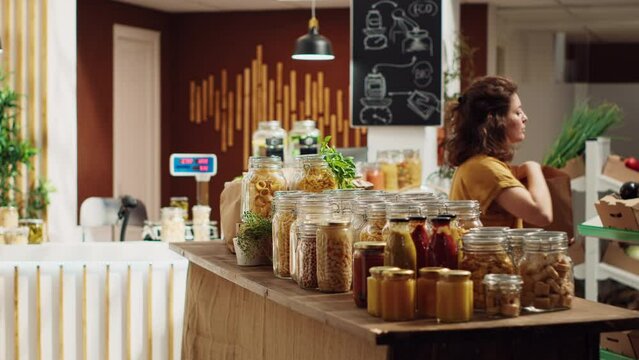 Customers shopping in eco friendly zero waste supermarket run by zealous storekeeper. Clients purchasing freshly harvested food from environmentally friendly local neighborhood store