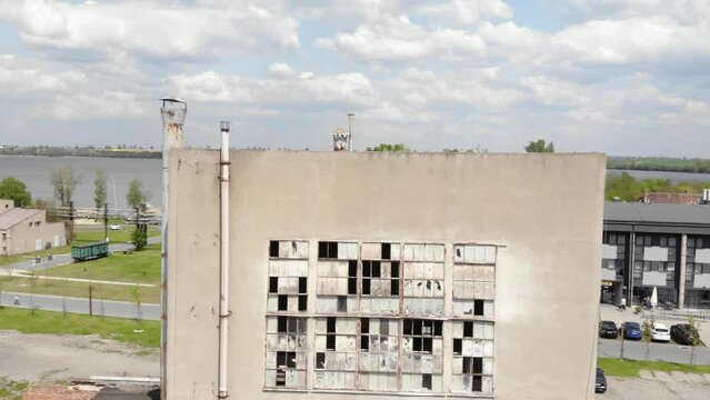 large, abandoned building with broken windows. The building is in a rural area of Cukrownia Żnin in Poland. Aerial Drone descending shot.