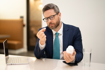 Man taking a medicine pill from headache migraine. Business man in suit with headache. Tired businessman is working overtime and has headache.