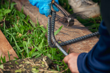 Construction Worker hands using pincer pliers iron wire. Outdoor Worker using wire bending pliers,...