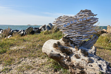 Fototapeta premium Wooden sculpture in the shape of a heart on the seashore. A heart that says only you.