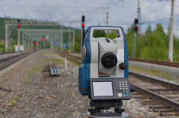 tachometer making geodetic survey with reels and traffic lights on the background