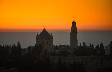 Dramatic sunrise in Israel. Synagogue view from above against orange sky and mountains line background. Sunrise view in Jerusalem, concept image for this war times.