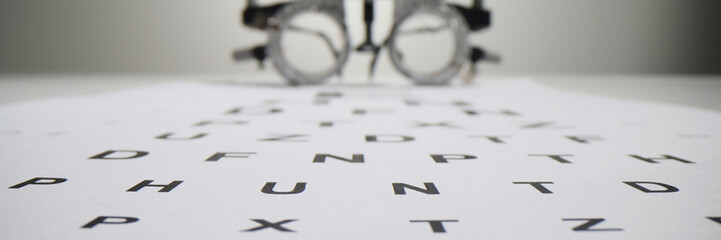 Snellen chart letters against blurred ophthalmology goggles